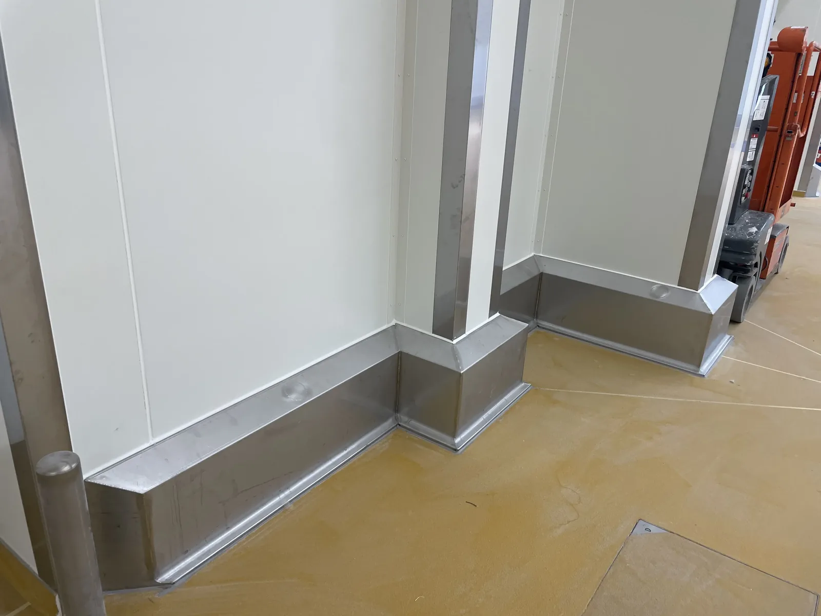 Plinthes de protection inox posées en pied de cloison lors d'une rénovation de salle propre